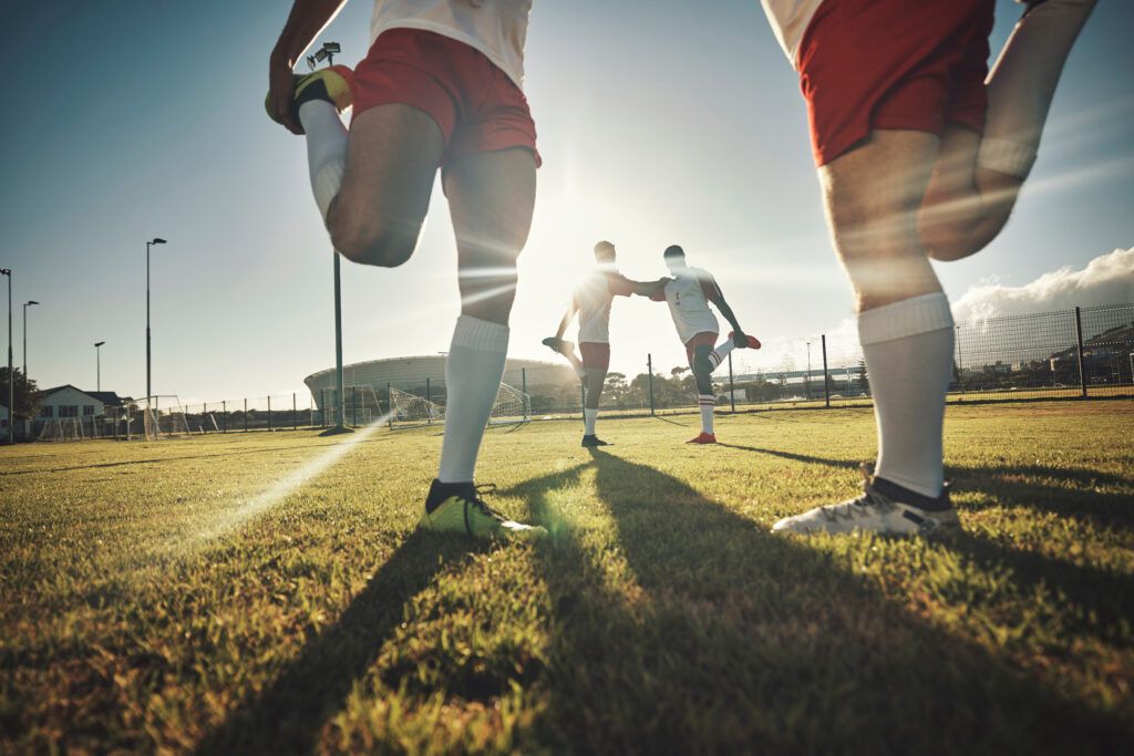 Soccer, team and stretching together on sport field for exercise, wellness and workout practice for.