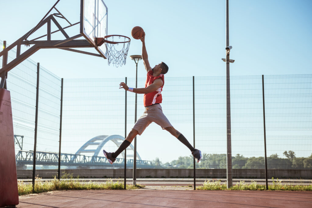 A young basketball player scoring a slam dunk.